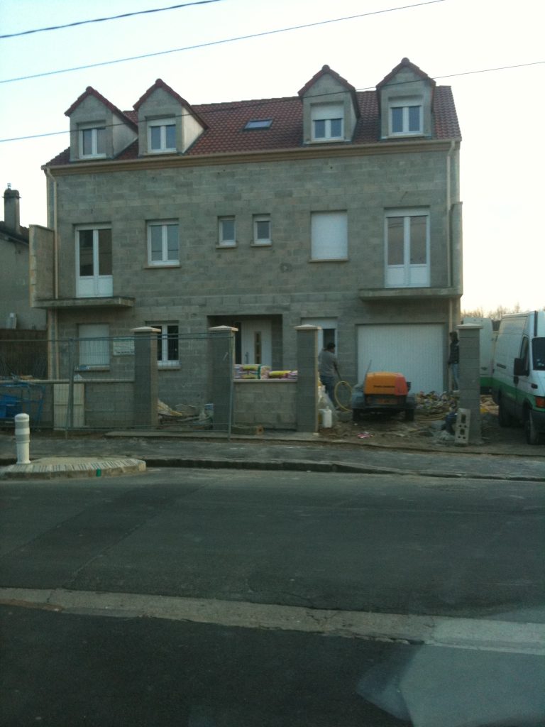 Maison en construction avec échafaudages.